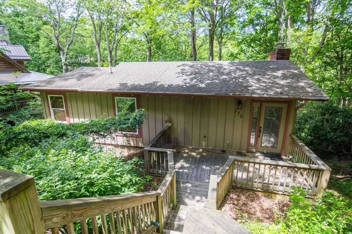 This exterior shot captures the welcoming front steps and house facade framed by lush, green landscaping. The inviting entrance evokes the feeling of returning to a comforting retreat after days filled with skiing, sightseeing, or family outings.